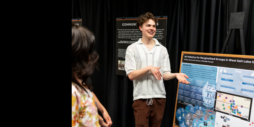 Student smiling while presenting poster with research data