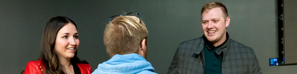 A student talking to two staff members.