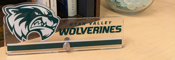 A desk nameplate labeled "Utah Valley Wolverines."