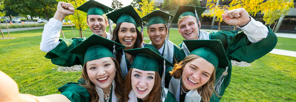 A group of graduating students cheering and celebrating.