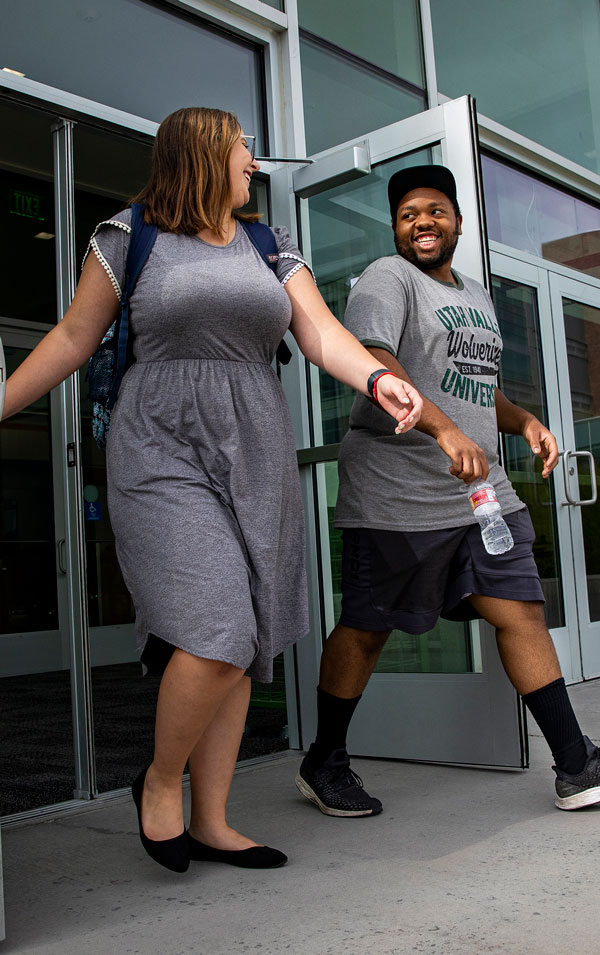 Two people exiting a building.