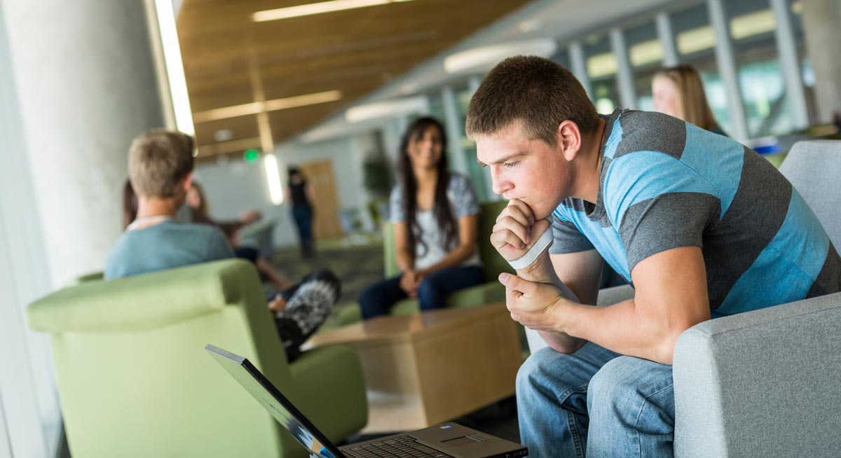 Three student success staff members talking in front of the reception desk.
