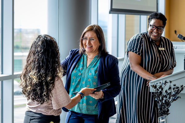 two women presenting a scholarship award to a UVU student