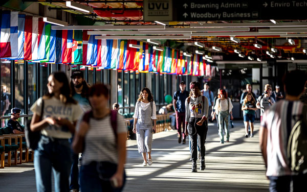 students walking in UVU's hall of flags