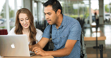 Students looking for information on a laptop computer