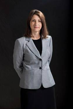 Photo of Susan Thackeray female with shoulder length hair wearing a black dress with grey blazer
