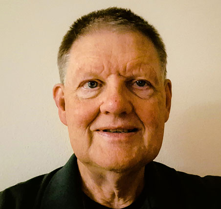 Photo of David Phillips. White older male wearing a dark shirt.
