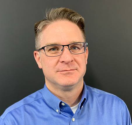 Photo of David Trent  a caucasian male with brown hair with a blue collared shirt wearing glasses