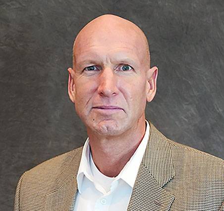 Photo of Jared Ellison a caucasian male who is bald, wearing a tan suit coat and white dress shirt