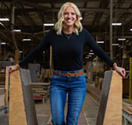 Photo of Kari Kovar a caucasian female with blonde hair standing in a warehouse.