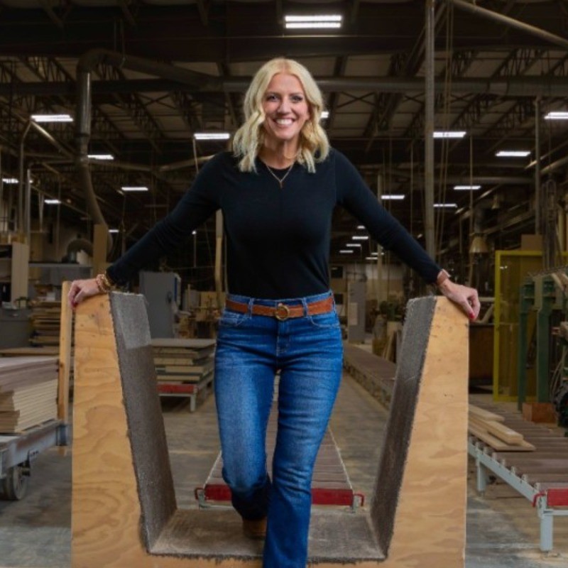 Photo of Kari Kovar a caucasian female with blonde hair standing in a warehouse.