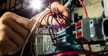 hands working on electrical equipment