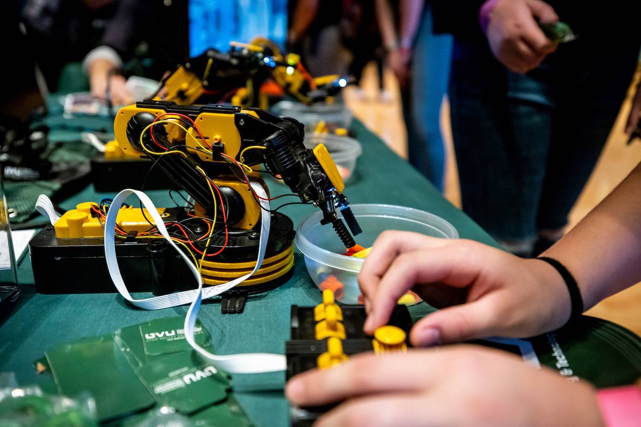 student controlling tiny robotic arm