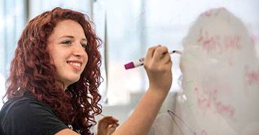 woman writing on a whiteboard