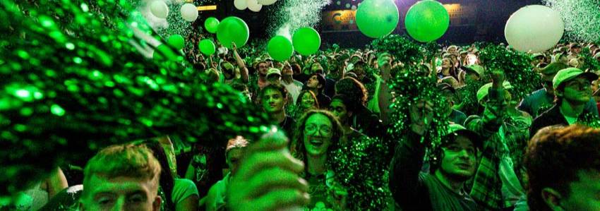 A UVU Weeks of Welcome party, there is confetti and balloons falling from the ceiling while students dance.
