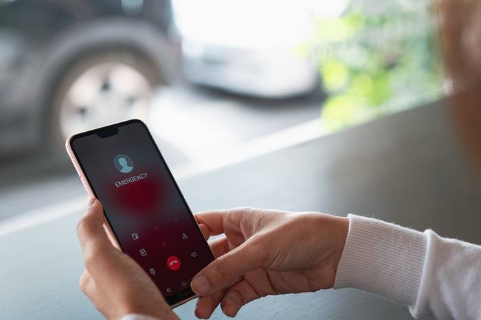 Hands holding an iPhone, that is connected to a call.