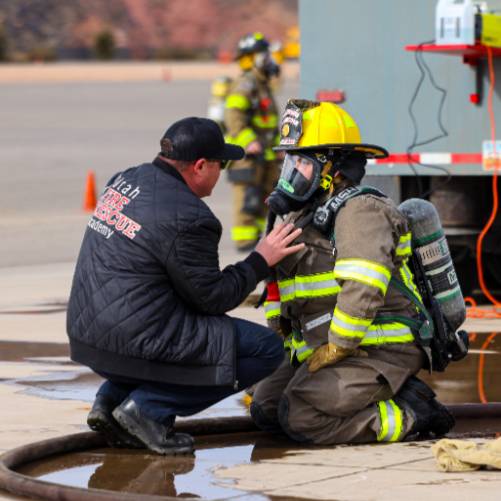 firefighter kneeling talking to a person