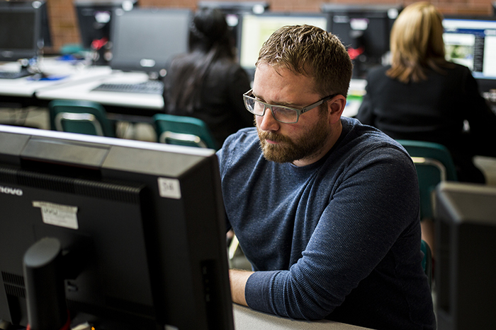 Man studying on a desktop computer in a lab