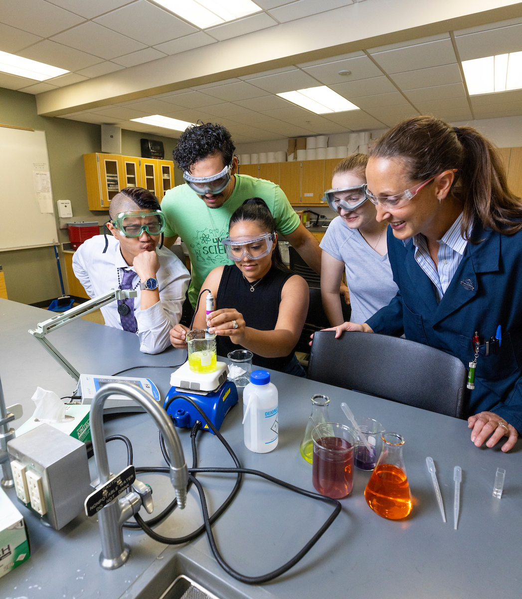 Image of a professor and their students in a science lab