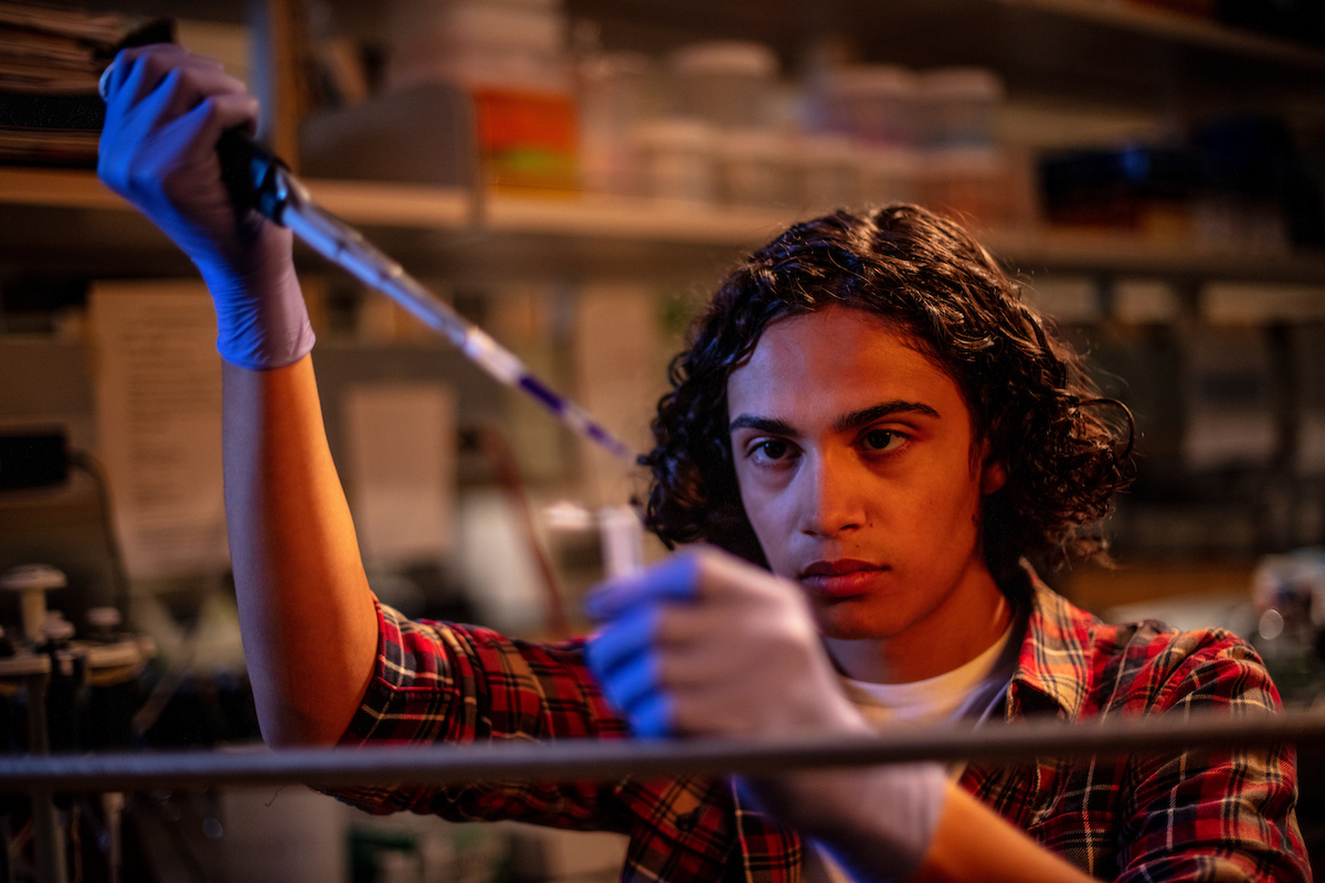 image of a student pouring a liquid into a beaker