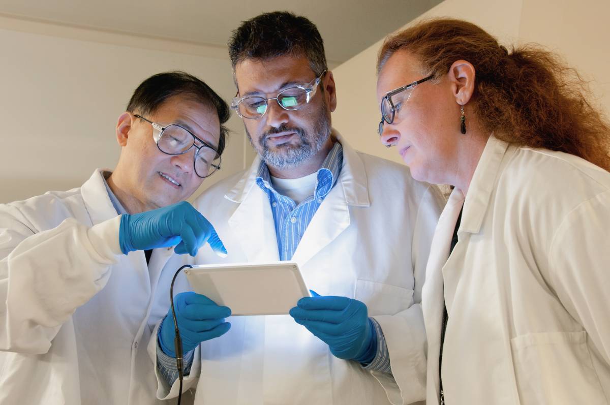 Image of researchers in lab coats and lab goggles