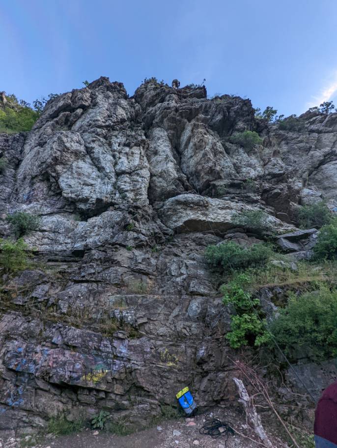 Image of a rock wall that people are preparing to climb