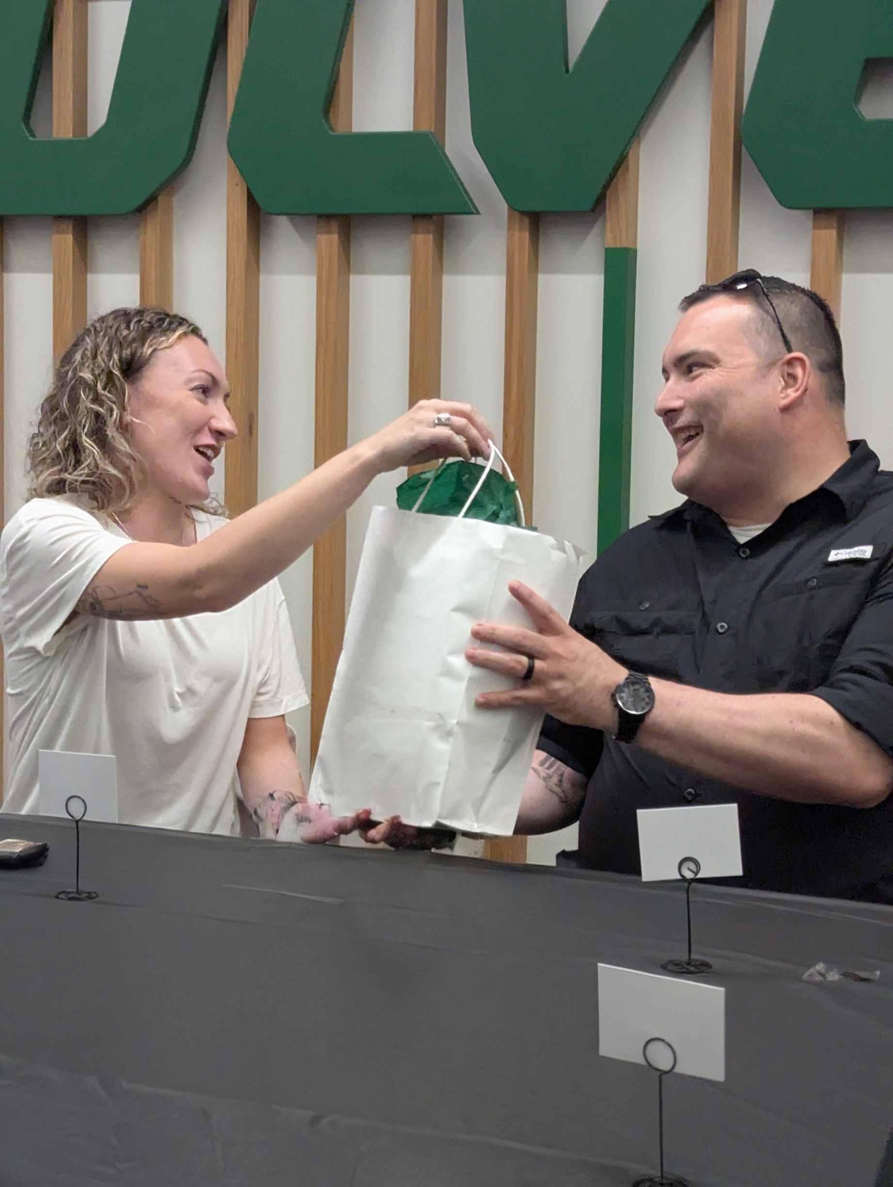 Tanicca Armstrong presents Tony Medina with the souvenirs.