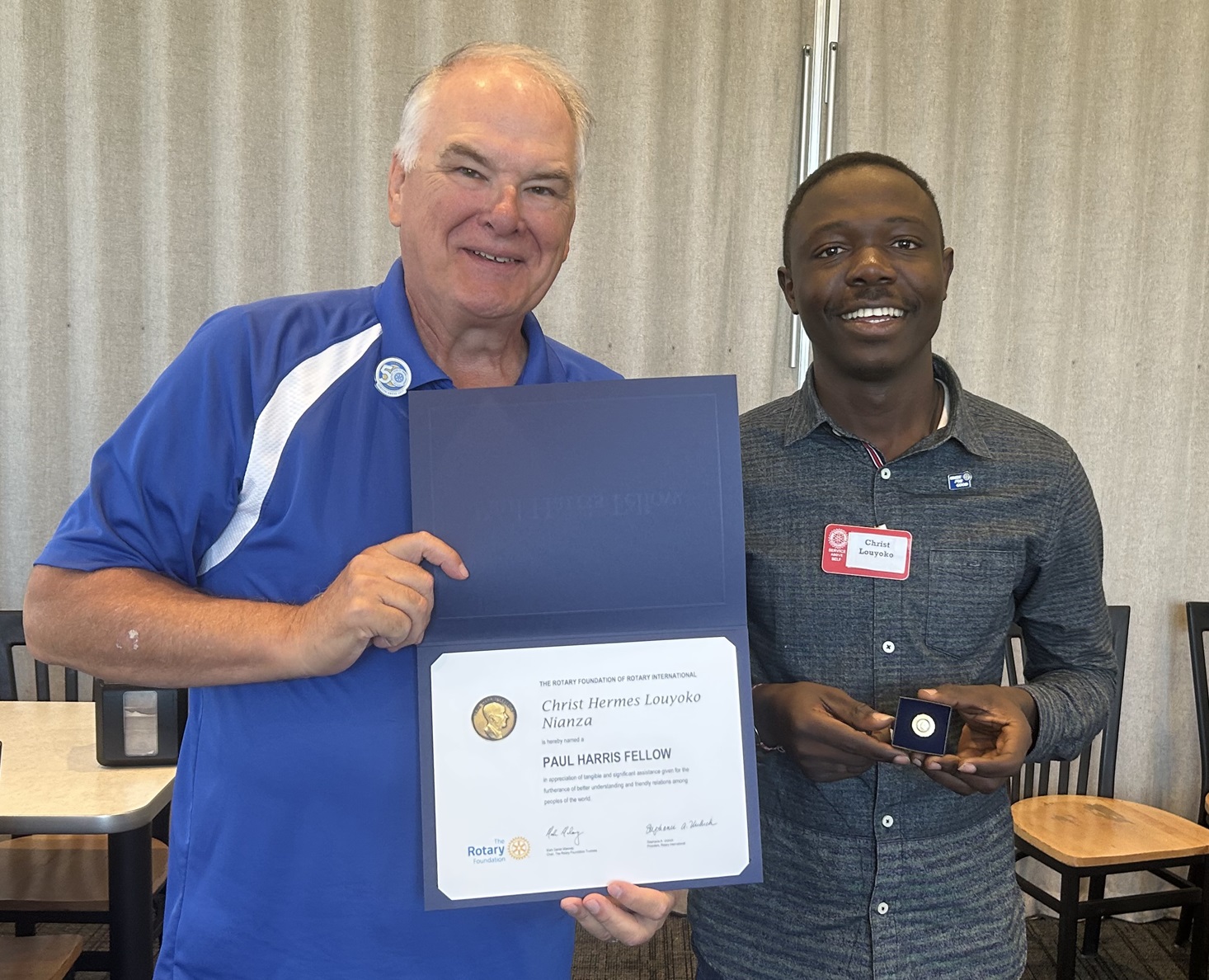 Louyoko Nianza, President of the Utah Valley University Rotaract receives  Paul Harris Award from Clark Merkley