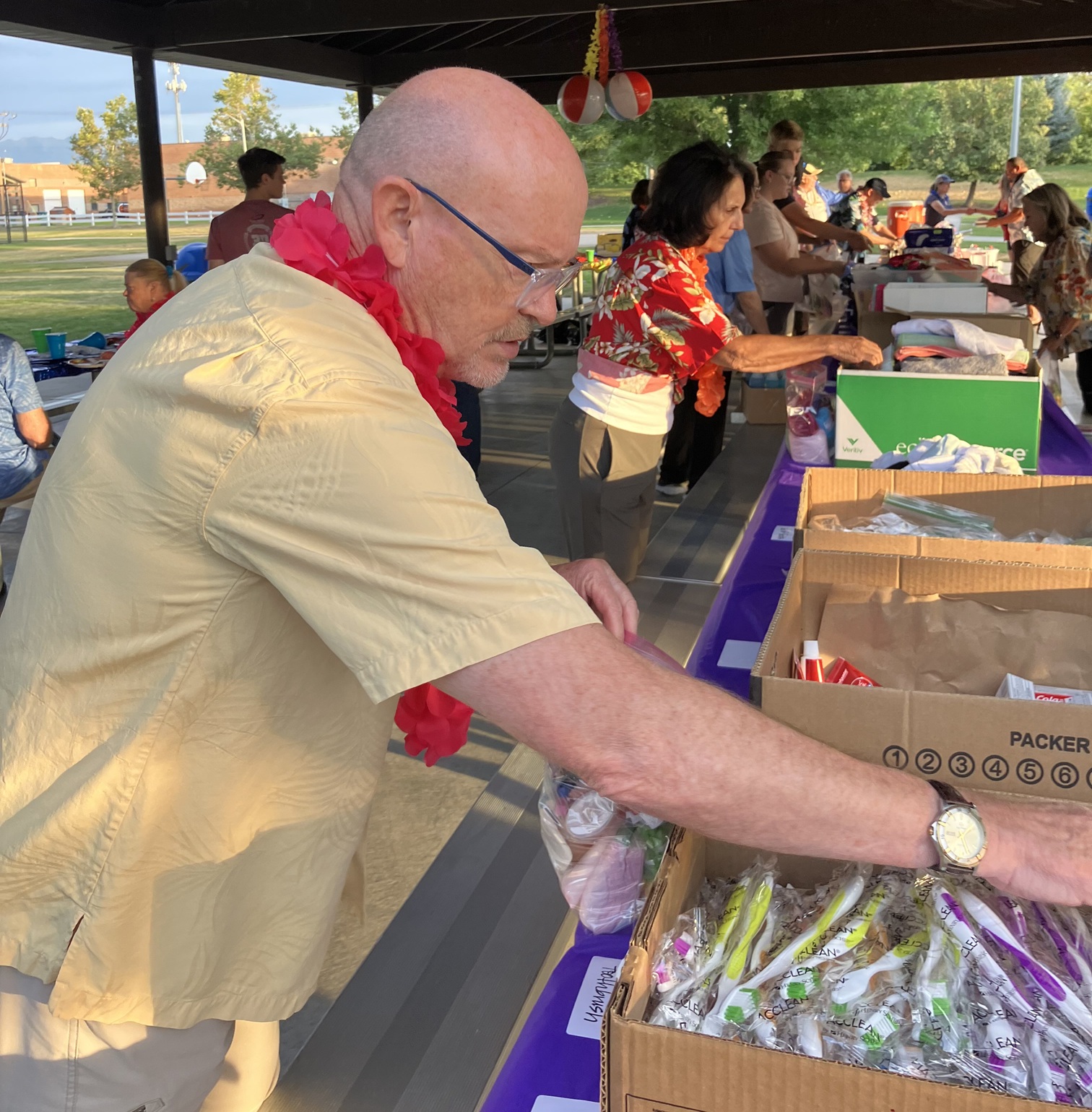 Assembling hygiene kits at long tables.