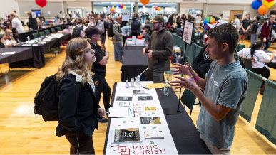 A female student talking to a male UVU employee at the Fall Part Time Job Fair