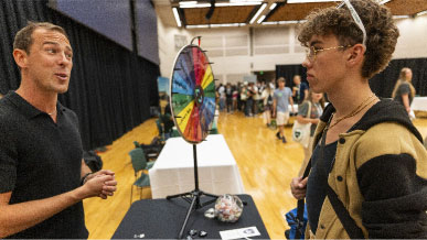 A male student talking to a male UVU employee at the Resource Fair