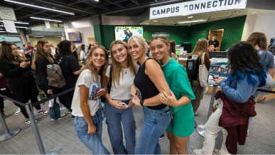 a group of women pose for a photo in front of campus connection at UVU