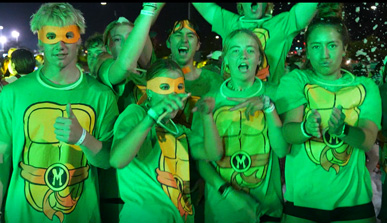 Four students dressed in green shirts dancing around at the Green Out Dance.