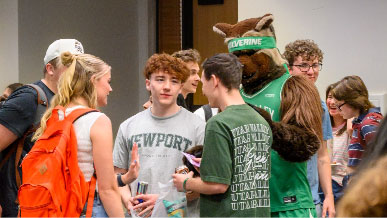 Students gather around talking to Willy the Wolverine