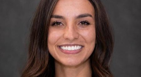 Image of Alessandra Camargo smiling with a dark grey background