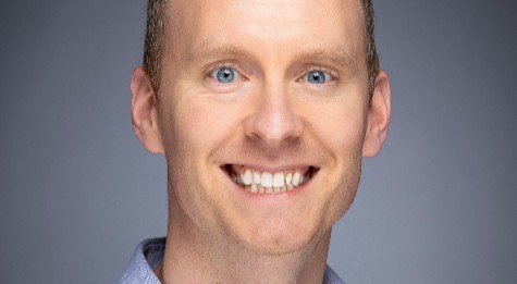 Image of Seth Jenson smiling with a dark grey background