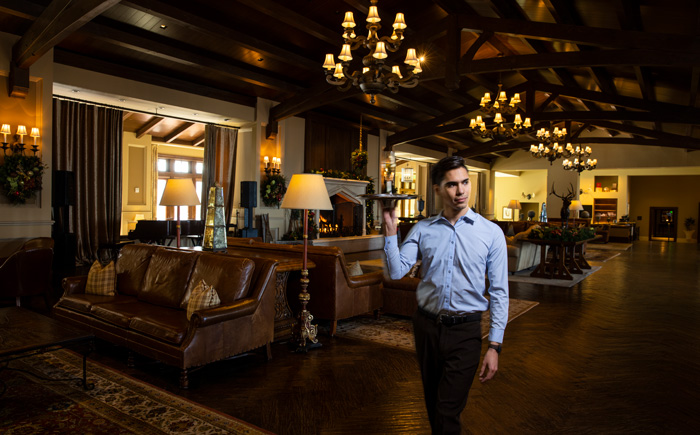 Server walking through hotel lobby with tray