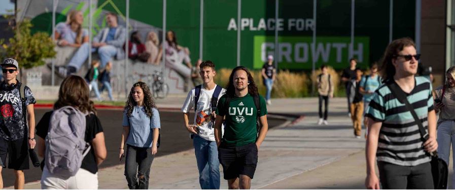 students walk across a college campus