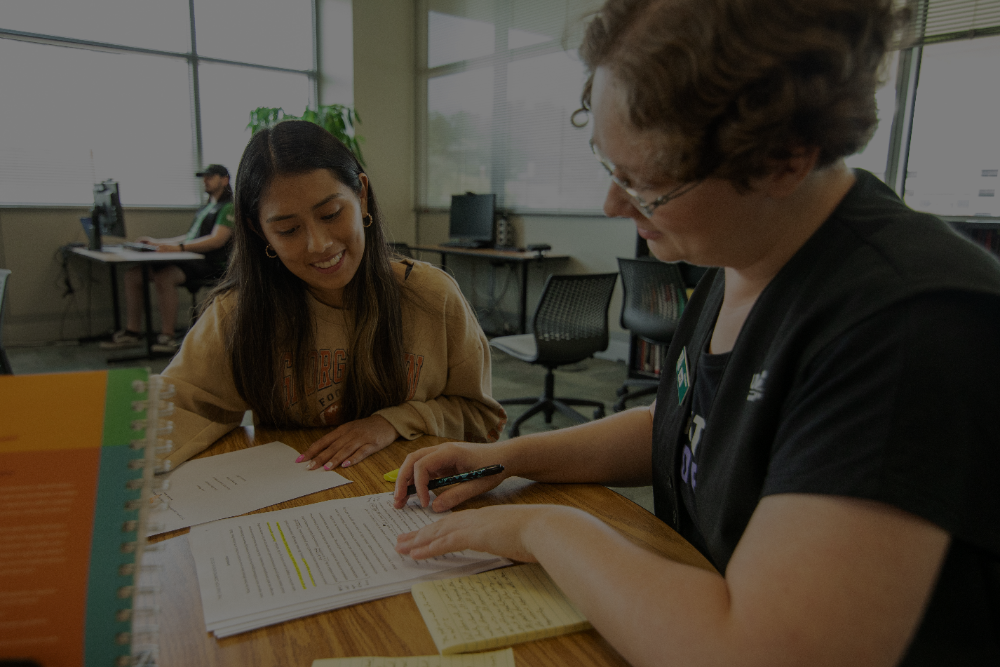 Image of a student working with a tutor at the Writing Center