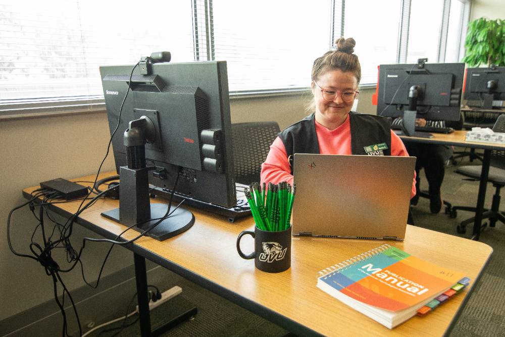 A Tutor typing on a computer in the Writing Center